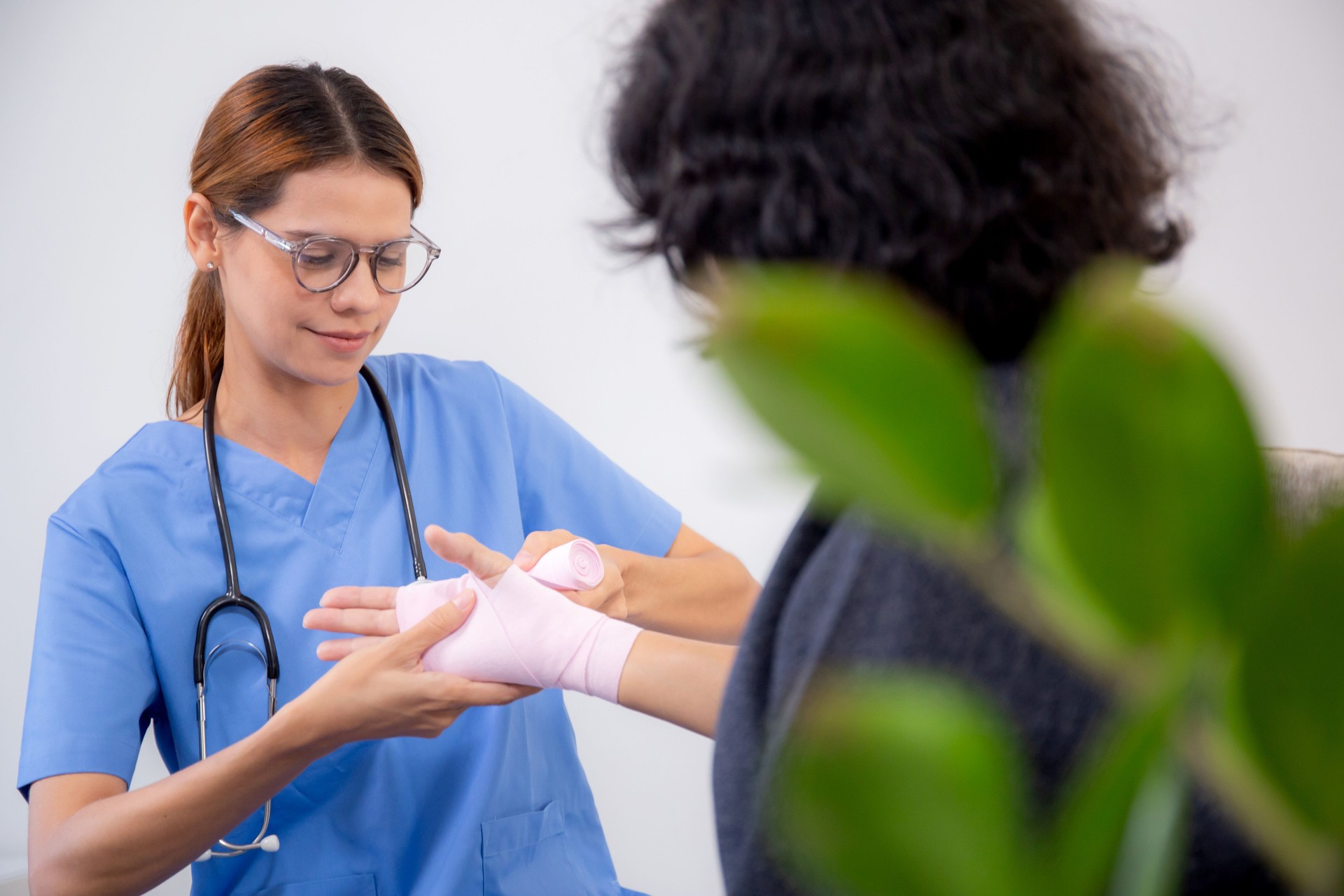 Doctor or nurse care patient senior woman with injury on hand while putting the bandage in living room at home, caregiver and emergency, elderly and treatment, medical and insurance concept.