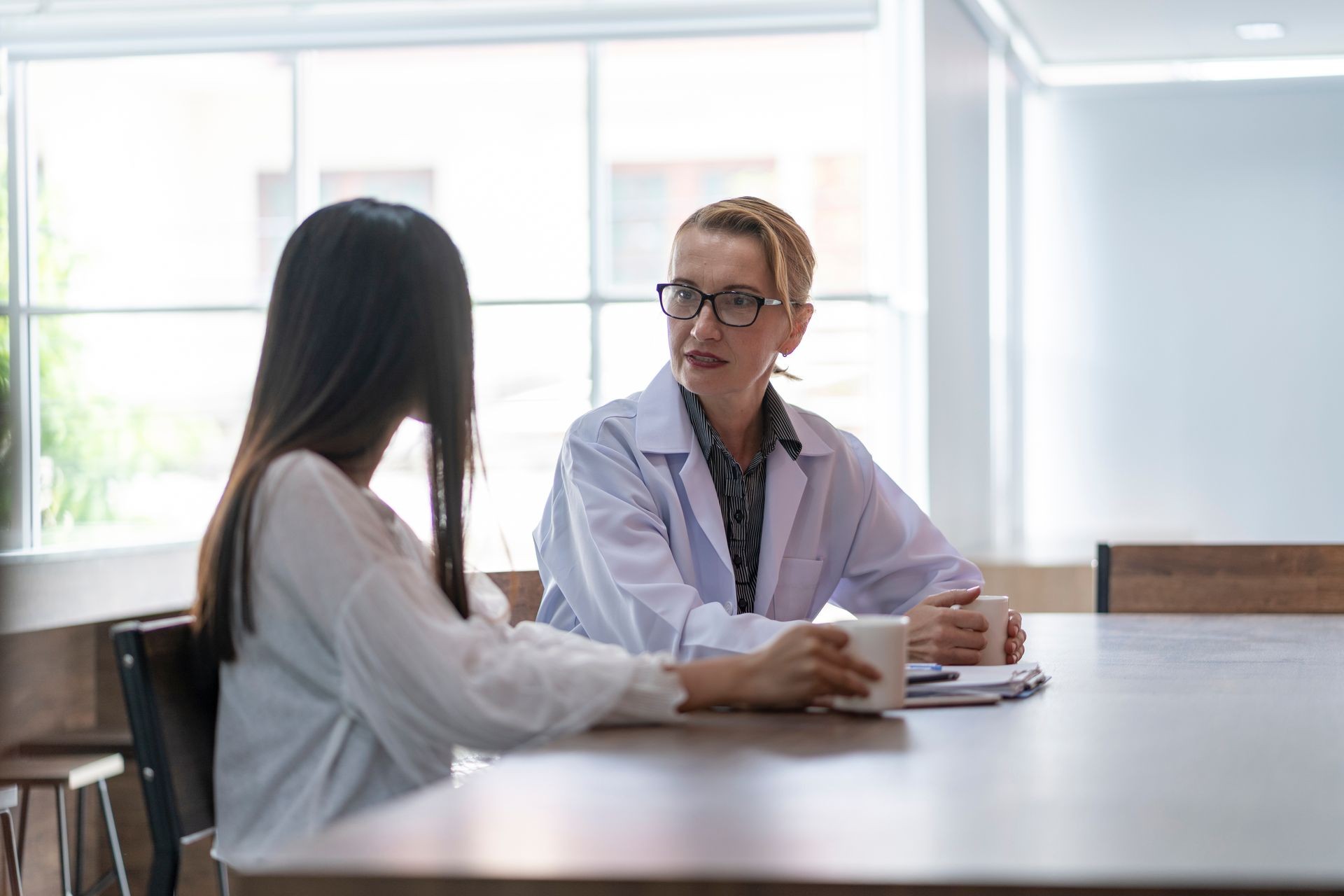 Senior female doctor explained something to the patient at the office.